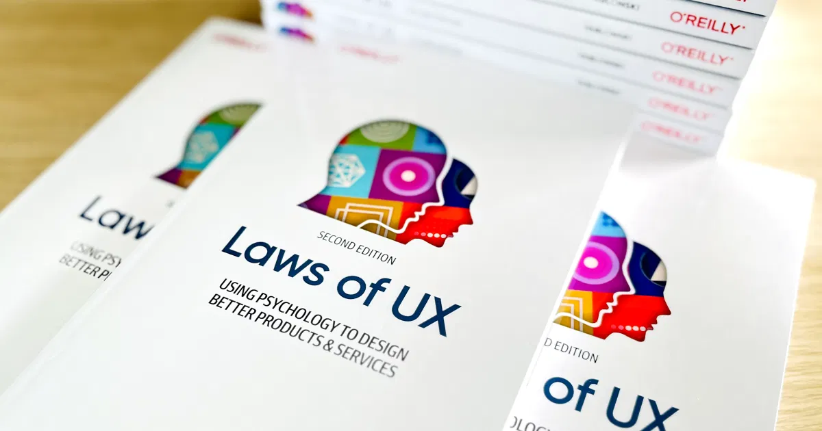 Jon Yablonski 著作《Laws of UX: Using Psychology to Design Better Products & Services》第二版實體書，由 O'Reilly 出版，數本疊放在木桌上