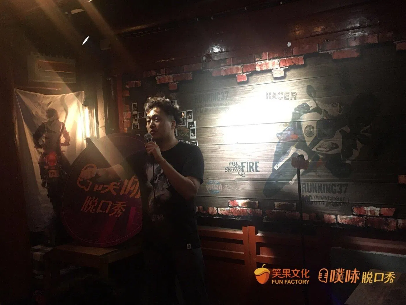東區德在脫口秀舞台上拿麥克風表演
