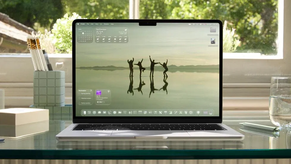 macOS 半透明毛玻璃介面：MacBook 桌面上視窗與選單呈現模糊透光的玻璃材質，背景色彩穿透到前景 UI