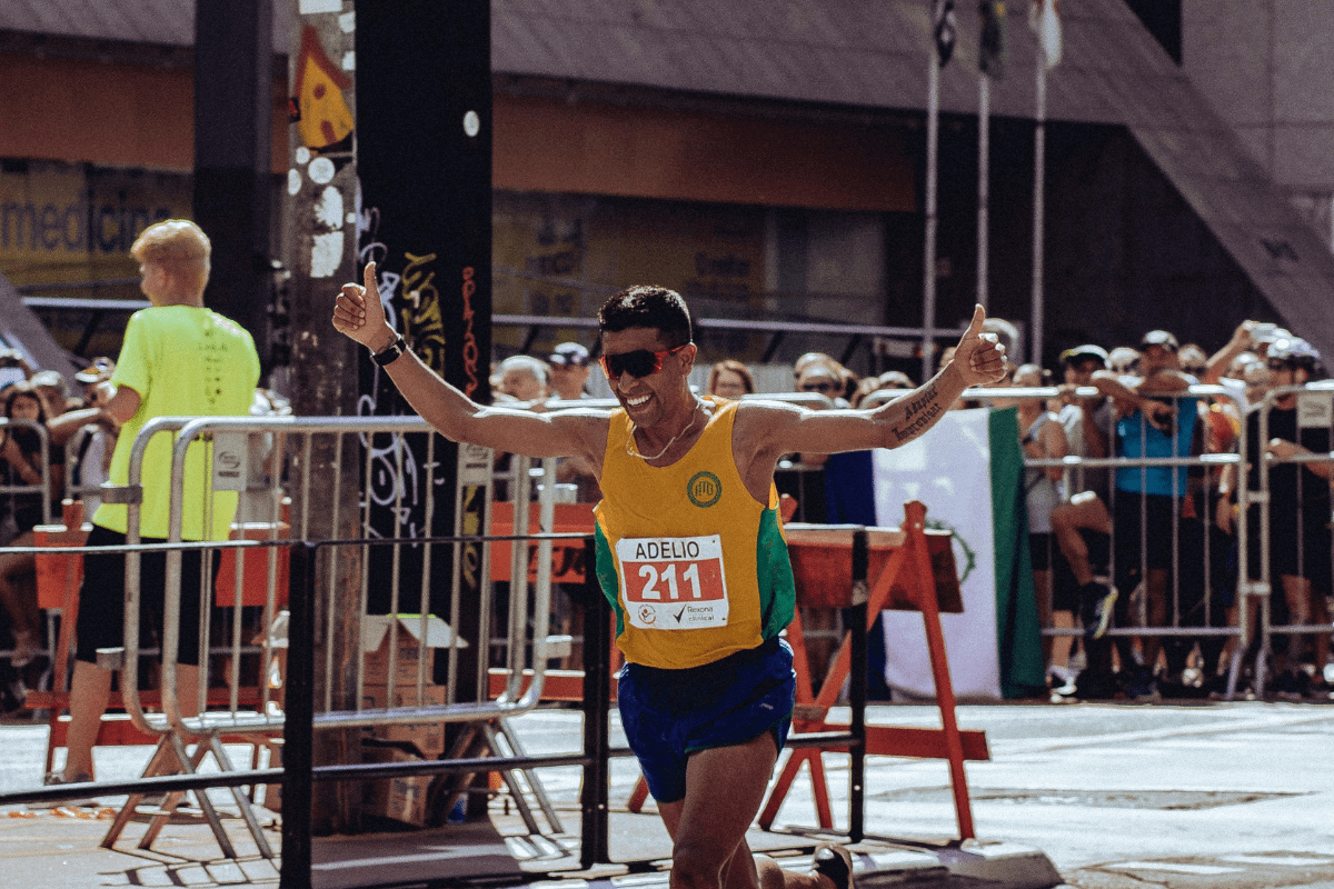 一張跑者突破 SUB 目標衝過終點線，高舉雙手慶祝的特寫照片。